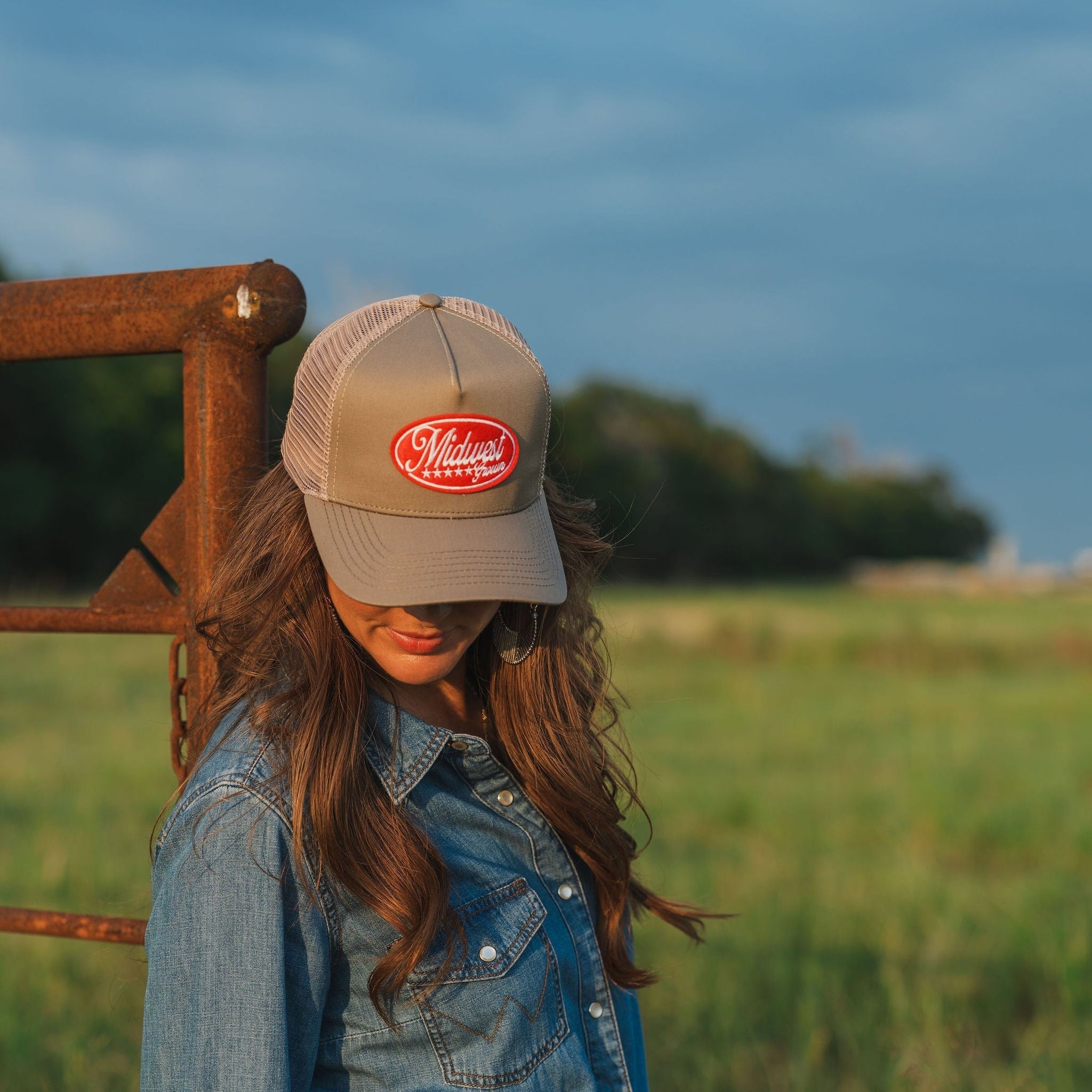 Woman wearing a Midwest Grown Hat with a logo in a field