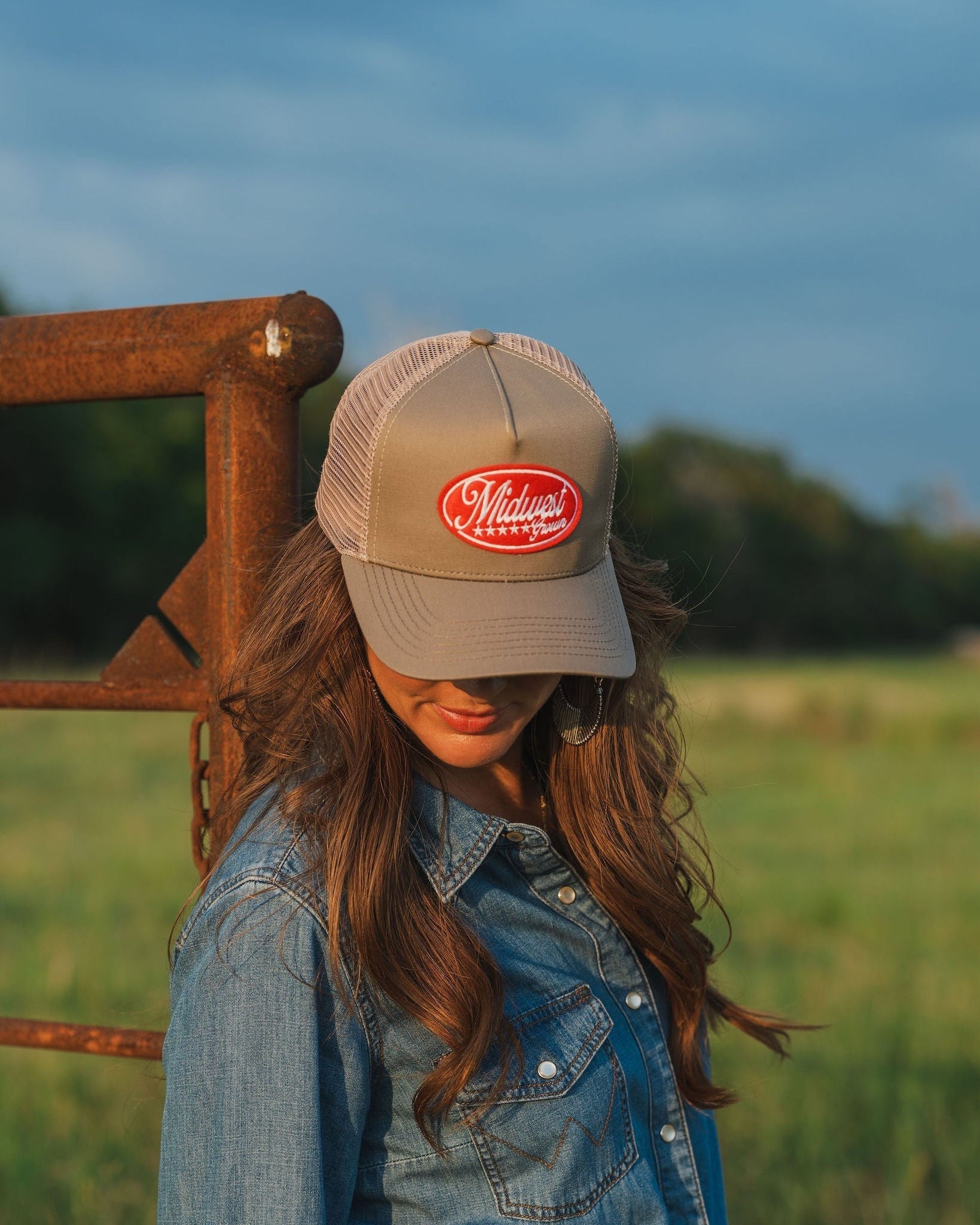 Woman wearing a Midwest Grown Hat with a logo in a field