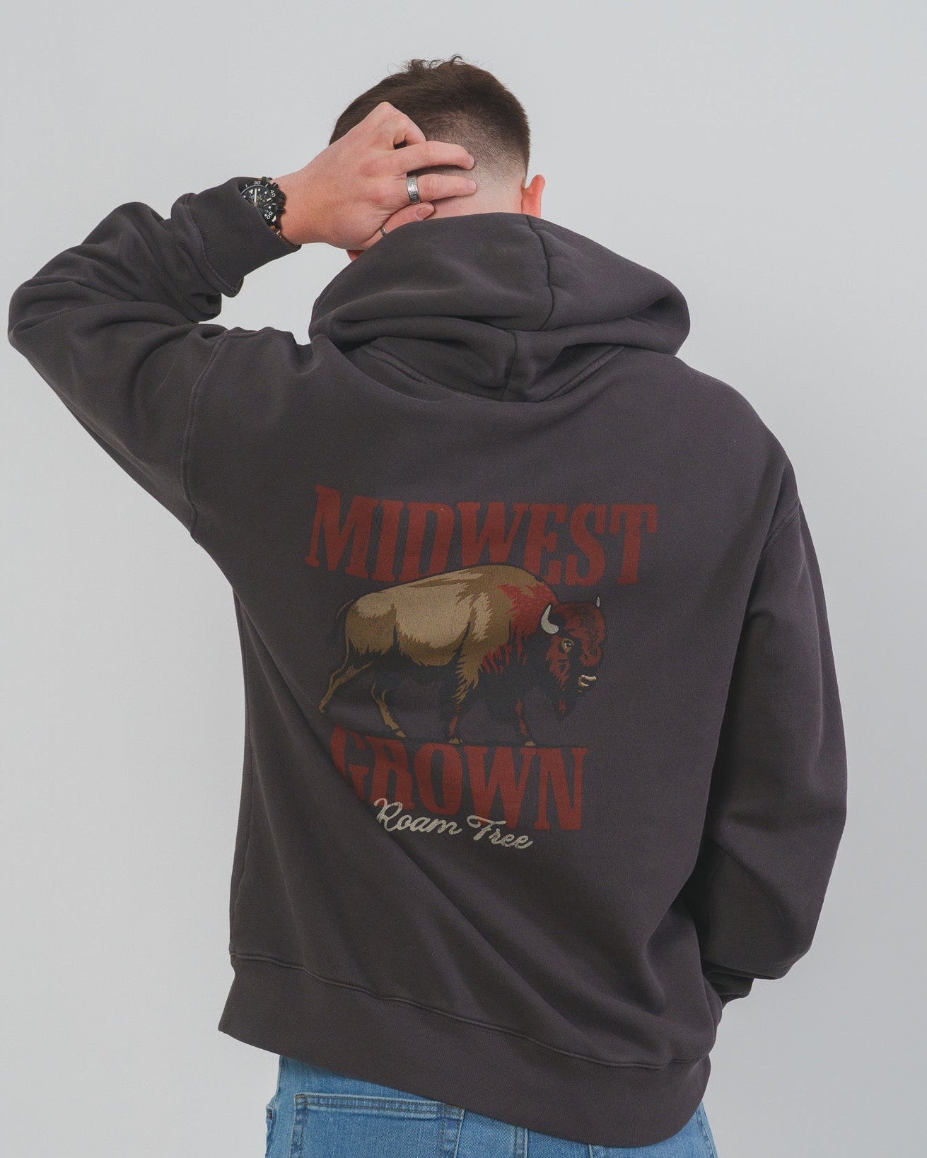 Person wearing a hoodie with 'Midwest Grown' text and graphic on the back, against a plain background.