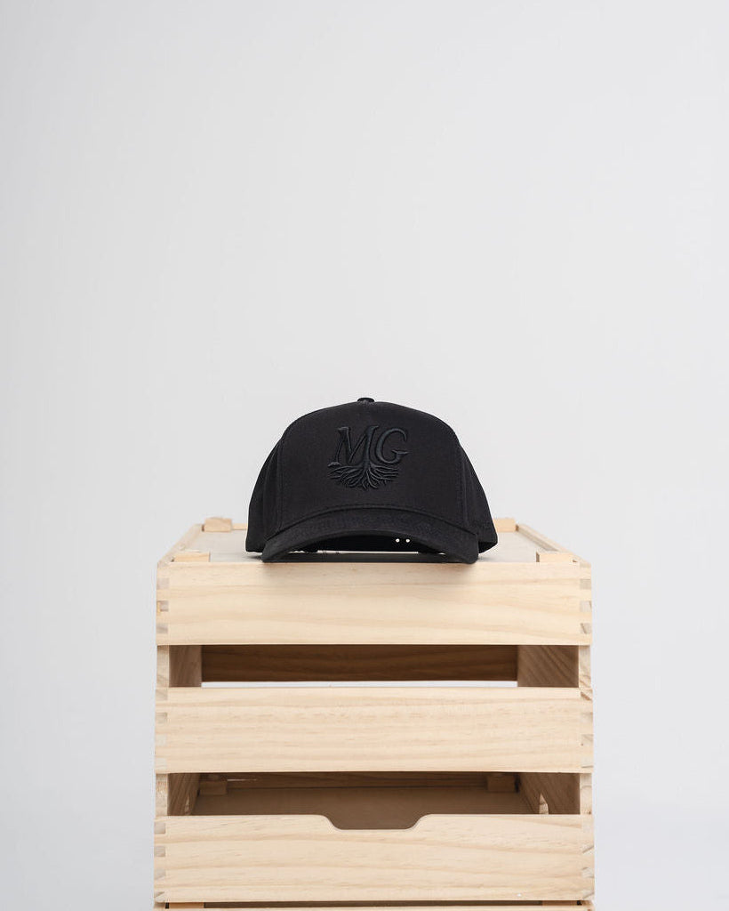 Black Midwest Grown cap on a wooden crate against a white background