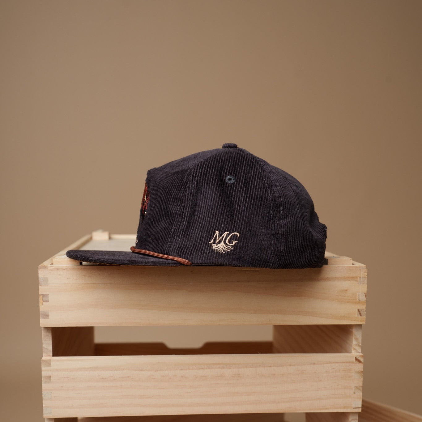 Vintage Black cap with 'Midwest Grown' logo on a wooden crate against a beige background