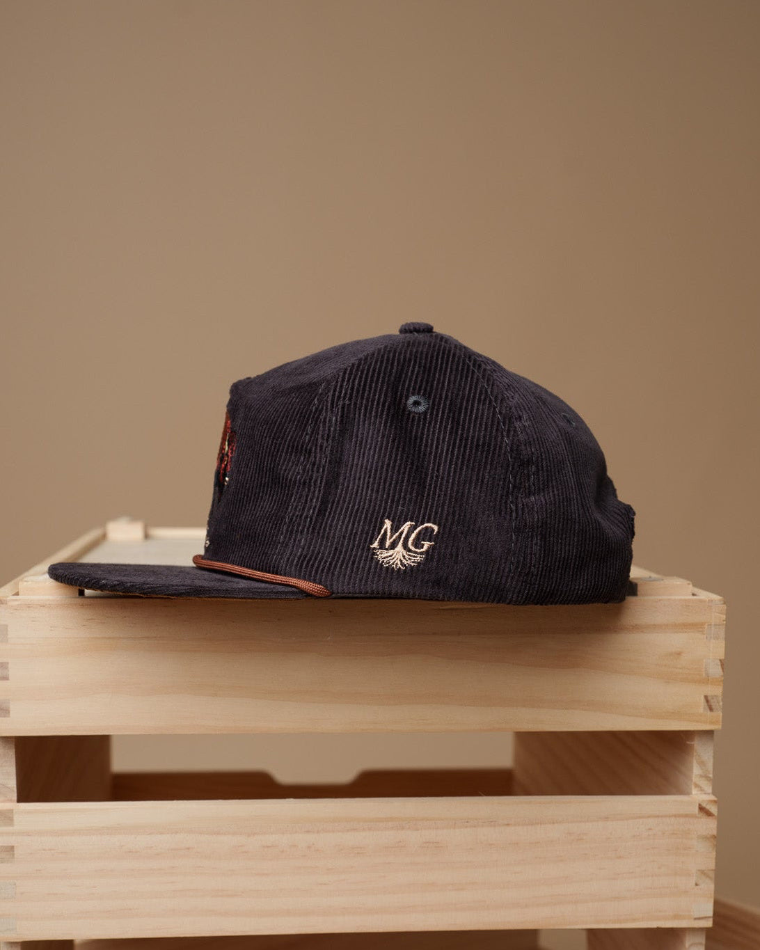Vintage Black cap with 'Midwest Grown' logo on a wooden crate against a beige background