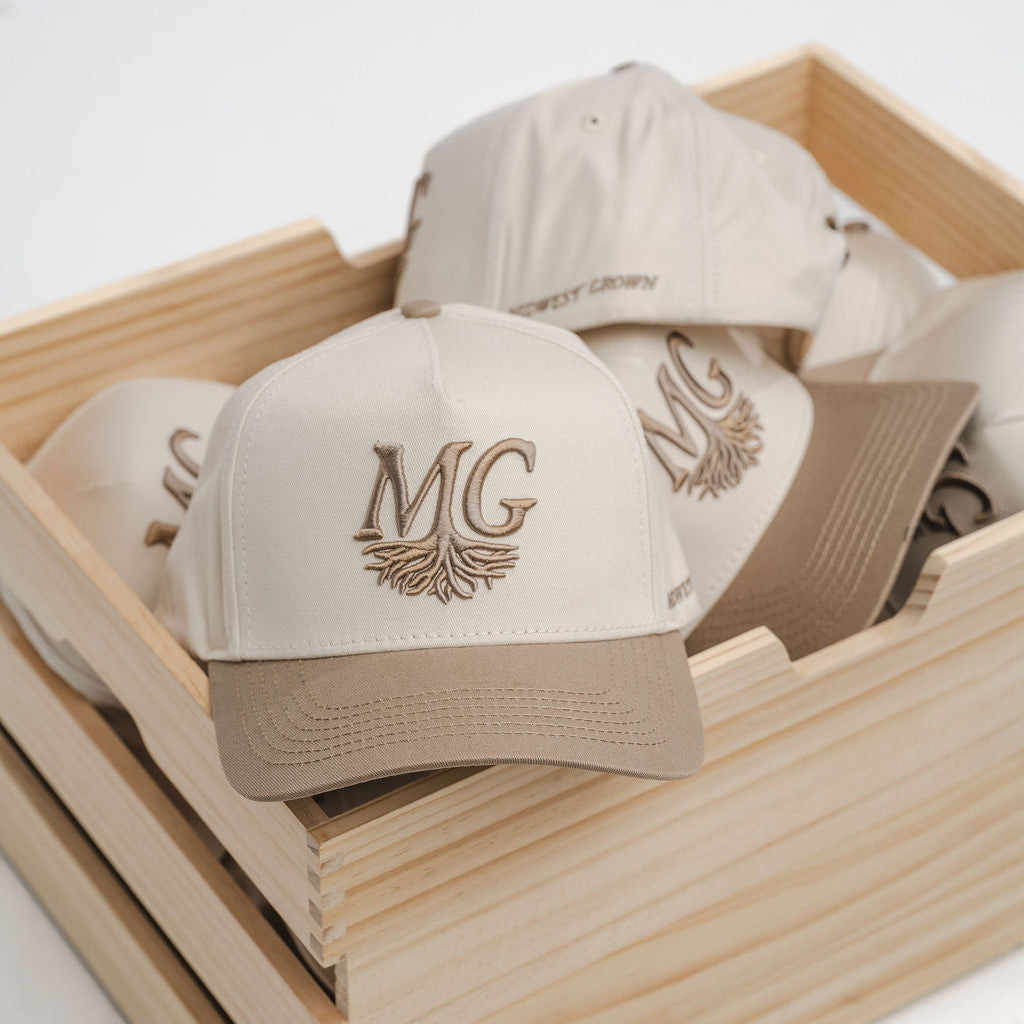 Beige caps with 'Midwest Grown' logo in a wooden box on a white background