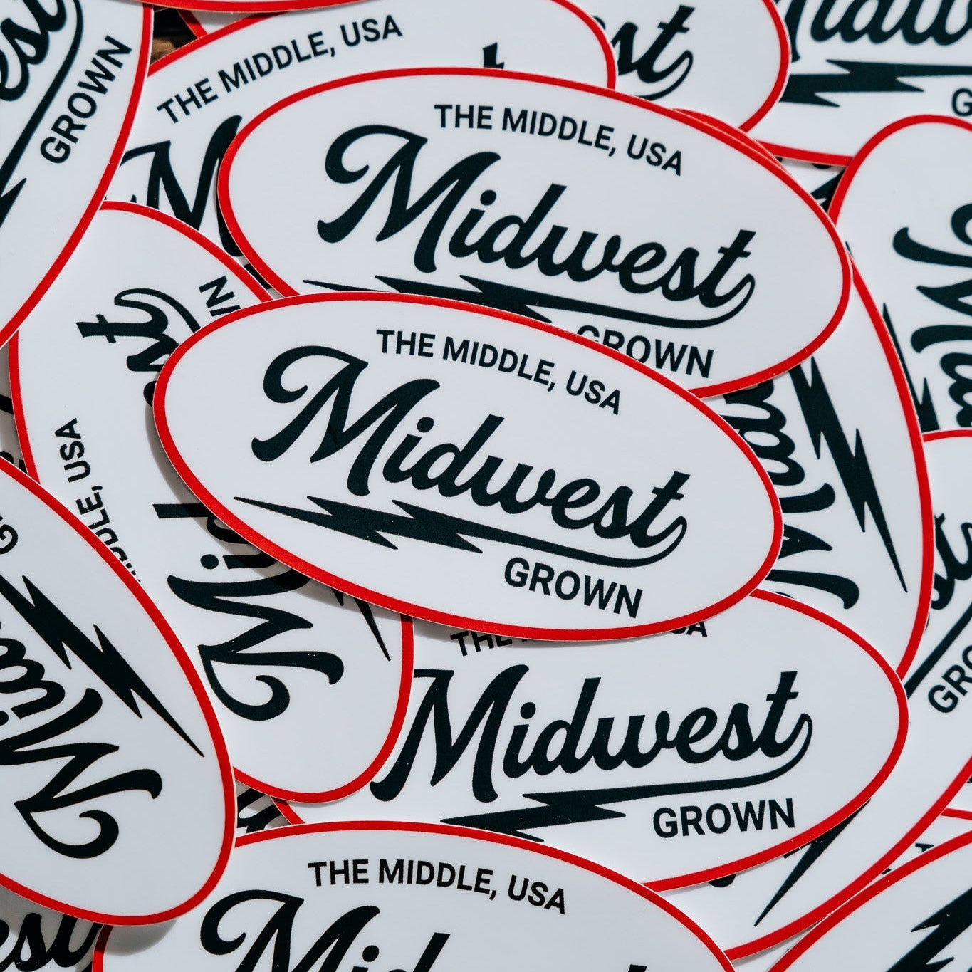 Stack of 'Midwest Grown' stickers with red borders on a white background