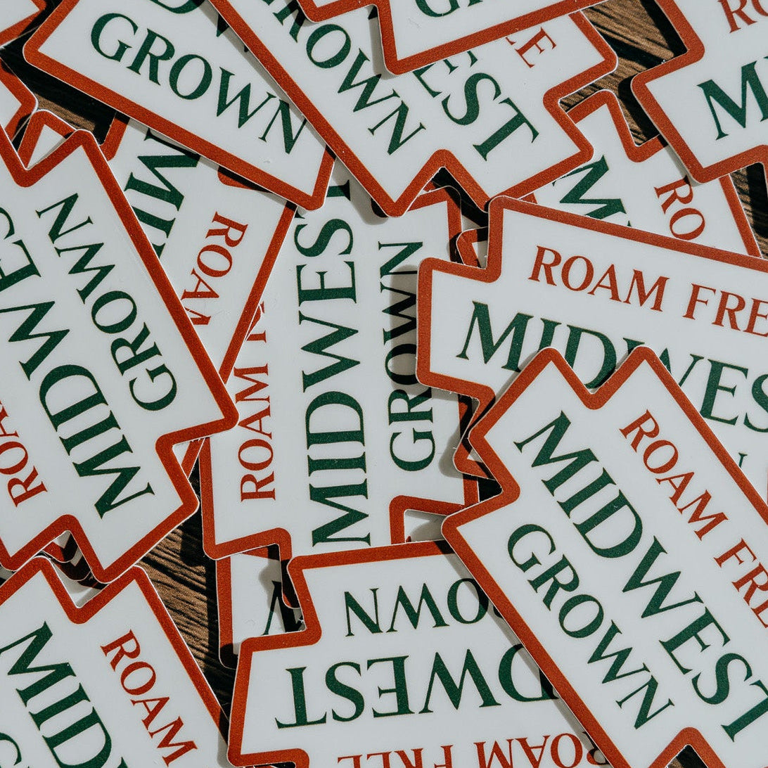Stack of 'Midwest Grown' and 'Roam Free' stickers.