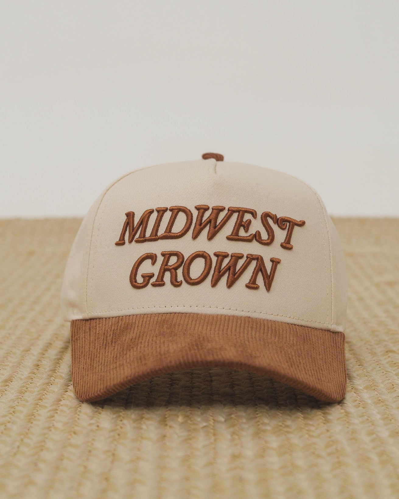 Beige and brown cap with 'Midwest Grown' text on a textured surface