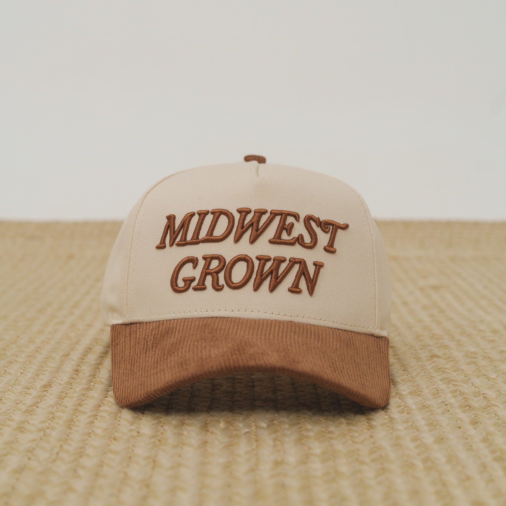 Beige and brown cap with 'Midwest Grown' text on a textured surface