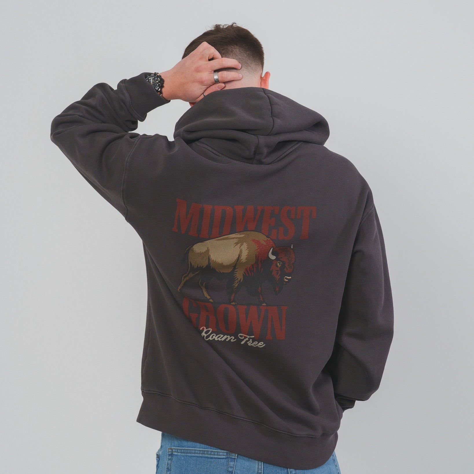 Person wearing a hoodie with 'Midwest Grown' text and graphic on the back, against a plain background.