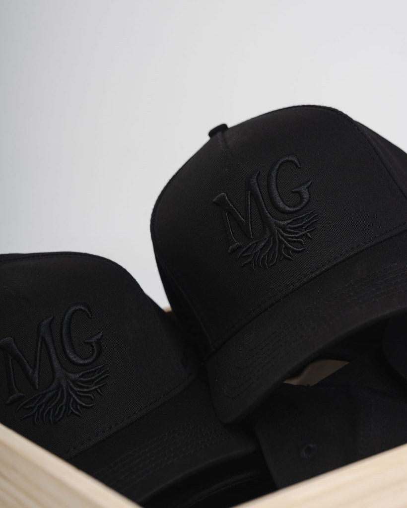 Black caps with a Midwest Grown logo on a light gray background